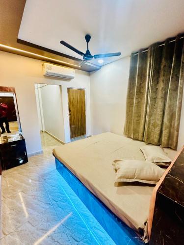 a large bed in a room with a ceiling fan at 1BHK Stay in Sibsāgar