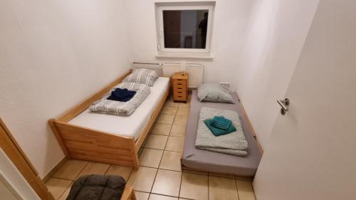 a small room with two beds and a window at Monteur- und Ferienwohnung Gemmer 52qm in Herold