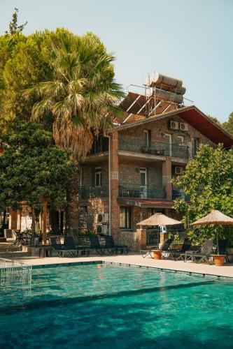 a swimming pool in front of a building at Ballı Butik hotel in Kayakoy