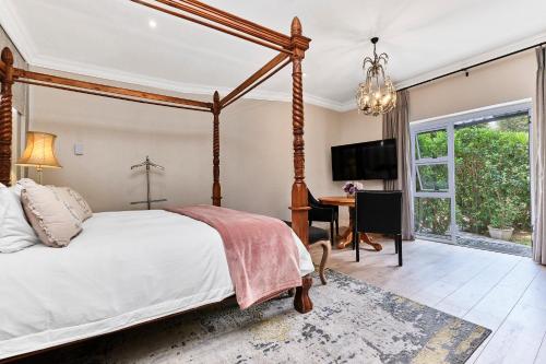 a bedroom with a canopy bed and a desk at Frnch on 2nd - Sandton in Johannesburg