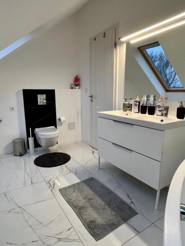 a white bathroom with a toilet and a sink at Interno Casa in Sopron