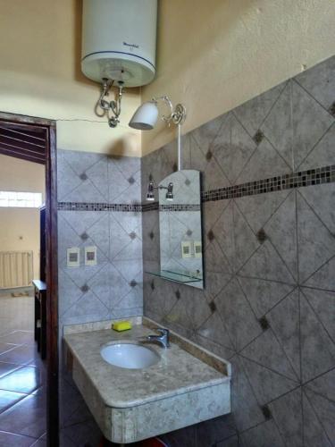 a bathroom with a sink and a mirror at La casa de Nimia in Asunción