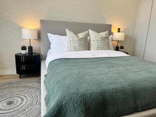 a bedroom with a bed with a green blanket and pillows at Unit 4913 - Ellipse Waterfall in Midrand