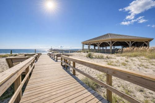 a wooden pathway to the beach with a gazebo at Captains Watch in Tybee Island