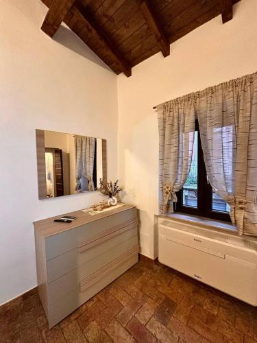 a bathroom with a dresser and a mirror and a window at Etruscan Brothers House in Cerveteri