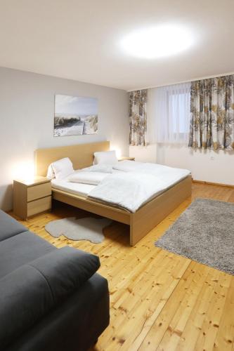 a bedroom with a large bed and a rug at Urbanihof in Jois in Jois