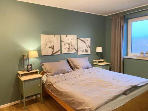 a bedroom with a bed with three paintings on the wall at Ferienwohnung, St Peter - Ording in Böhl