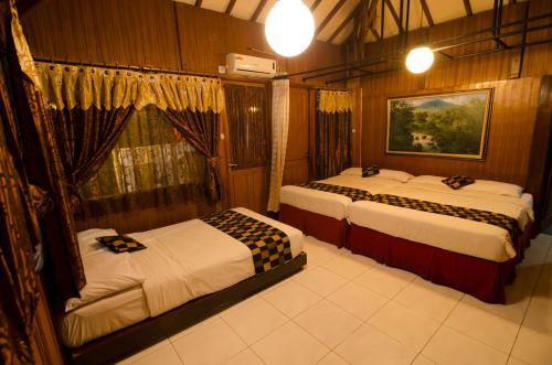 a bedroom with two beds and a window at Fora Guest House Taman Lingkar in Bandung
