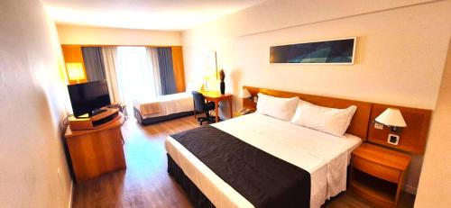 a hotel room with a bed and a television at SOL FLAT 1805 Alphaville Hotel & Residence in Barueri