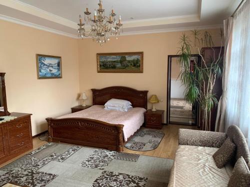 a bedroom with a bed and a couch and a mirror at Luxury Apartaments 3 in Truskavets