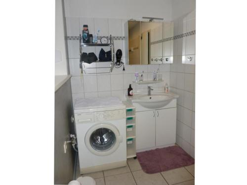 a bathroom with a washing machine and a sink at Ferienwohnung Plett in Barlt