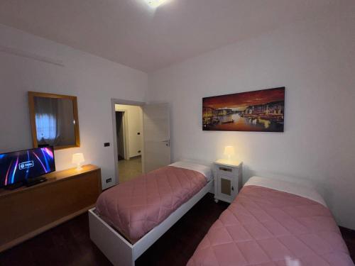a bedroom with two beds and a tv at Sweet charm in Venice in Tessera