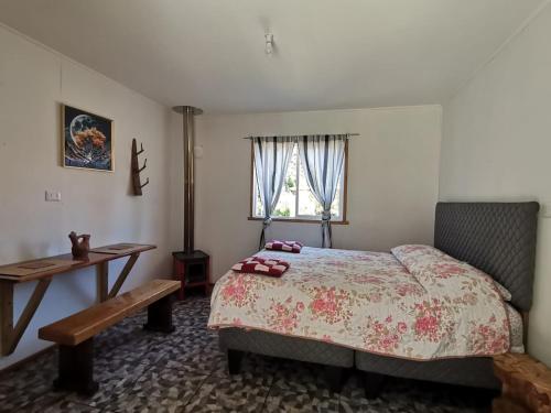 a bedroom with a bed and a table and a window at tiny house kiñeco melipeuco conguillio in Santa María