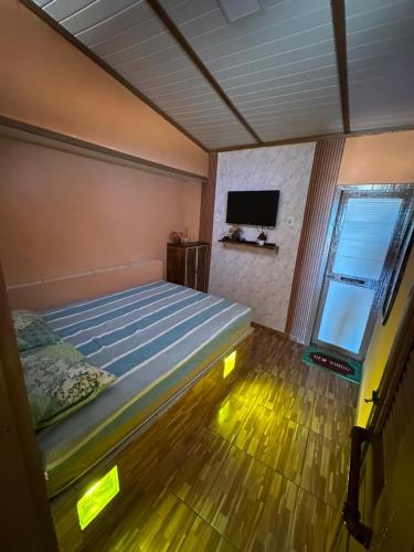 a bedroom with a bed and a flat screen tv at Sereia beach chalé in Icapuí
