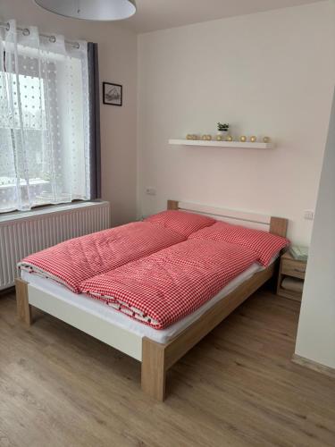 a bedroom with a bed with a red comforter at V Talutě in Chyšky