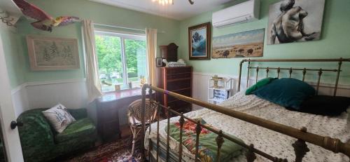 a bedroom with a bed and a chair and a window at Trout House by Trout Lake in Vancouver