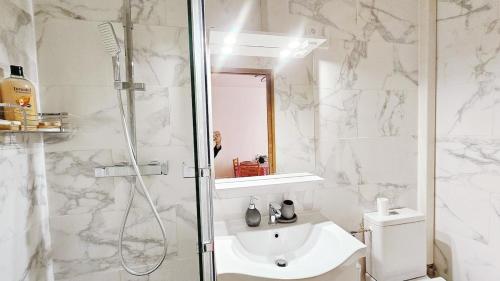 a white bathroom with a shower and a sink at Nice apt with parking free in Paris