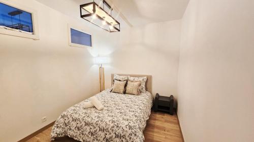 a small bedroom with a bed and a lamp at Nice apt with parking free in Paris