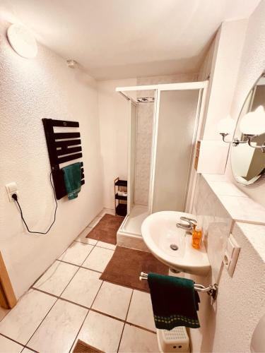 a white bathroom with a sink and a shower at Ferienwohnung momentglücklich in Eggingen in Eggingen