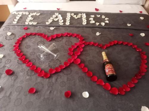 a bottle of champagne and a heart on a bed at Hotel Florencia in Mexico City