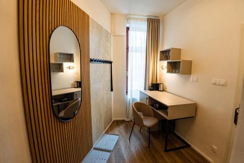 a bathroom with a mirror and a desk with a chair at Arte Brno in Brno