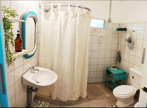 a bathroom with a shower curtain and a sink at Refugio Urbano Sentite como en casa en Comodoro Rivadavia in Comodoro Rivadavia