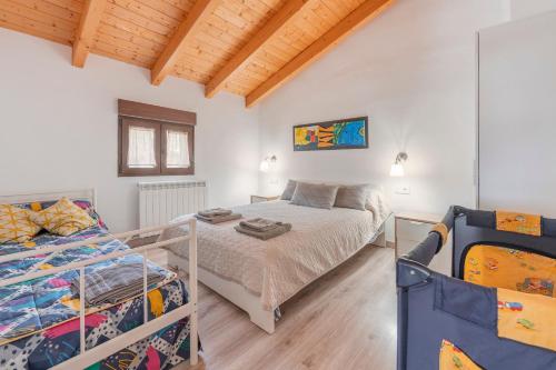 a bedroom with two beds in a room with wooden ceilings at Casa Rural Casa Clemen in Villalba Baja