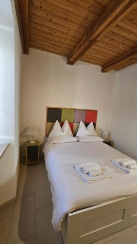 a bedroom with a large white bed with a wooden ceiling at TorreCielo in Foligno