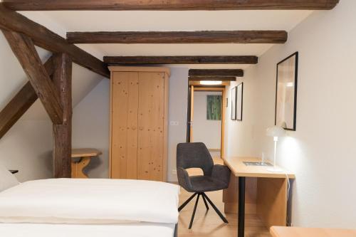 a bedroom with a bed and a desk and a chair at Hotel Garni Promenade in Weißenhorn