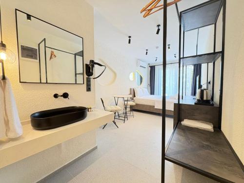 a bathroom with a black sink and a bedroom at Arıcan Pansiyon in Fethiye