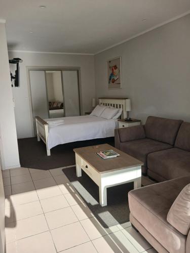 a living room with a bed and a couch at Reefton in Reefton