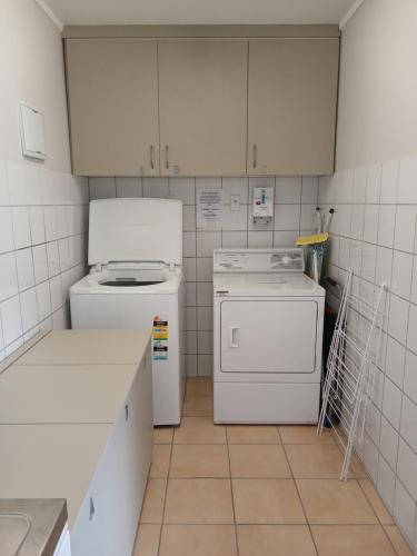 a kitchen with a stove and a washer at Reefton in Reefton