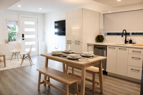 a kitchen with a wooden table with dishes on it at 2BDR Stylish Comfort Parkside in Vancouver