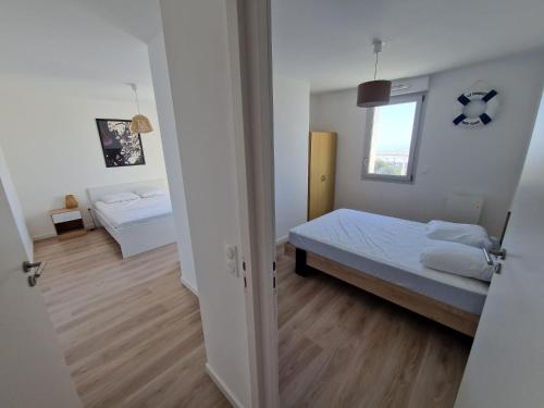 a small bedroom with a bed and a window at L'effet Mer de Stella in Stella-Plage