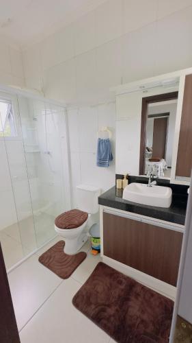 a bathroom with a toilet and a sink and a shower at Kitnet beira da lagoa in Terra de Areia