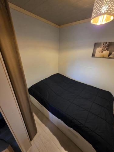 a bedroom with a black bed in a room at Les deux écureuils in Vresse-sur-Semois