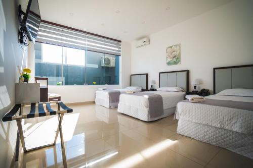 ein Schlafzimmer mit zwei Betten und einem großen Fenster in der Unterkunft HOTEL INNOVA in Tarija