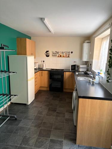 a kitchen with a white refrigerator and wooden cabinets at STOCKTON CONTTRACTOR DIGs in Stockton-on-Tees