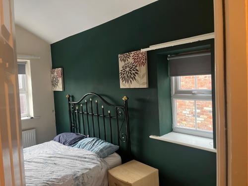 a green bedroom with a bed and a window at STOCKTON CONTTRACTOR DIGs in Stockton-on-Tees