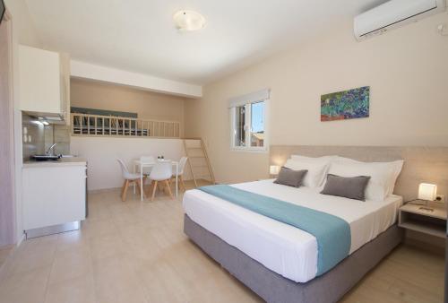a bedroom with a large bed and a kitchen at Alexandra's Residence in Kefallonia