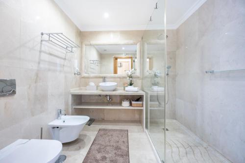 a bathroom with a toilet and a sink and a shower at Infinity Penthouse in Lagos