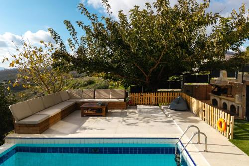 a swimming pool with a couch and a table next to a swimming pool at Villa Bijoux SeaView Pool near Athens airport in Neos Voutzas