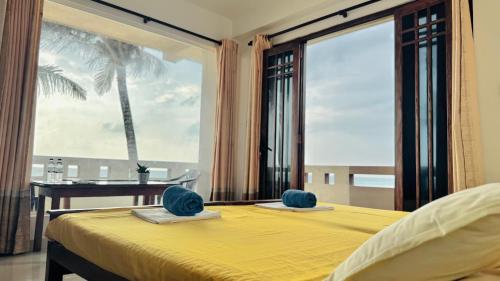 a bedroom with a yellow bed with a view of the ocean at Vacation Beach in Hikkaduwa