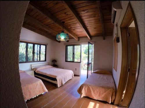 a bedroom with two beds and a chandelier at Casa Grande Lomas de Cocoyoc in Texcalpan