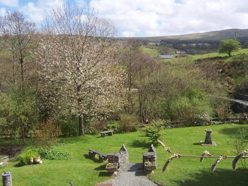 a park with benches in the grass with a hill at Penmachno Hall - self catering suite in Betws-y-coed