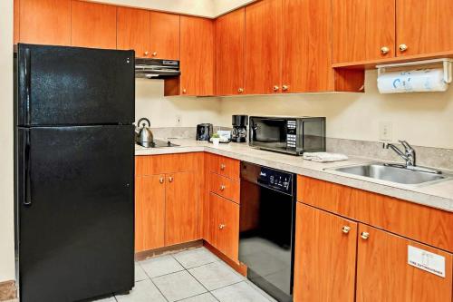 a kitchen with a black refrigerator and a sink at Modern Condo With Pool & Hot Tub - Universal Studios in Orlando