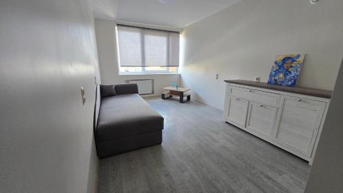 a living room with a couch and a window at Hostel istaba in Rēzekne