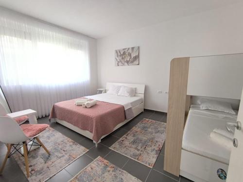 a bedroom with a bed with a pink bedspread at Tale Sunset Apartment in Lezhë