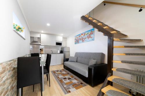 a living room with a staircase and a kitchen at Duplex Moderno Perto da Praia in Armação de Pêra