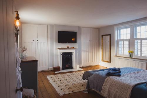 a bedroom with a bed and a fireplace and a television at Luxury House sleeps 14 with Secret Bar near Bath in Warminster
